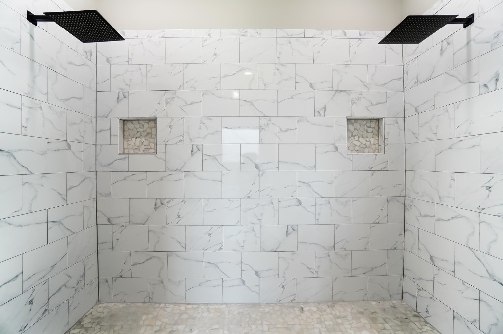 Modern walk-in shower — marble-look tile, dual rain shower